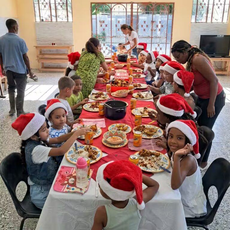 Niños en mesa compartiendo alimentos en comunidad