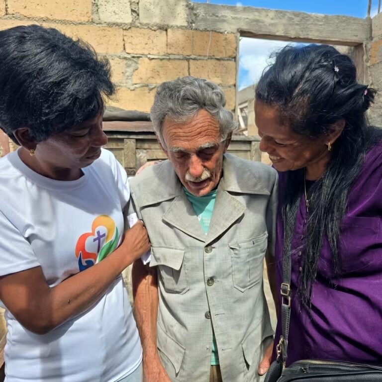 Voluntarios orando por persona mayor